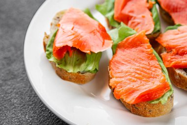 Somon sandviçi kırmızı balık deniz ürünleri aperatif taze gurme yemek arka planı masa rustik gıda üst görünüm fotokopi alanı pesseeter diyet