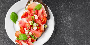 Jambon, domates, yeşillik taze lezzetli gurme yemek arkaplanı masa kırsal yiyeceklerin üst görünümü fotokopi alanı.