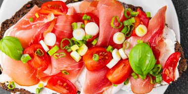 Jambon, domates, yeşillik taze lezzetli gurme yemek arkaplanı masa kırsal yiyeceklerin üst görünümü fotokopi alanı.