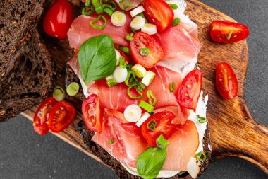 Jambon, domates, yeşillik taze lezzetli gurme yemek arkaplanı masa kırsal yiyeceklerin üst görünümü fotokopi alanı.