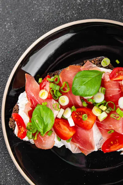 Jambon, domates, yeşillik taze lezzetli gurme yemek arkaplanı masa kırsal yiyeceklerin üst görünümü fotokopi alanı.