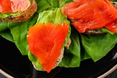 Somon sandviçi kırmızı balık deniz ürünleri aperatif taze gurme yemek arka planı masa rustik gıda üst görünüm fotokopi alanı pesseeter diyet