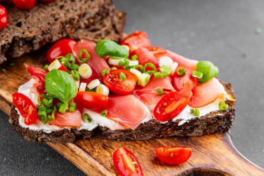 Jambon, domates, yeşillik taze lezzetli gurme yemek arkaplanı masa kırsal yiyeceklerin üst görünümü fotokopi alanı.