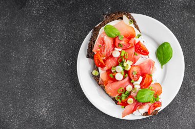 Jambon, domates, yeşillik taze lezzetli gurme yemek arkaplanı masa kırsal yiyeceklerin üst görünümü fotokopi alanı.