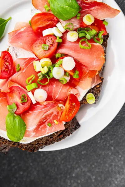 Jambon, domates, yeşillik taze lezzetli gurme yemek arkaplanı masa kırsal yiyeceklerin üst görünümü fotokopi alanı.