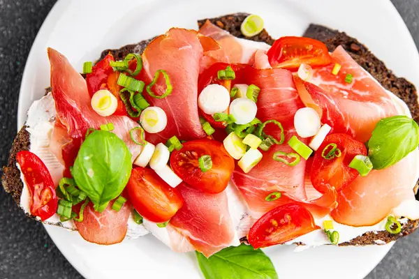 Jambon, domates, yeşillik taze lezzetli gurme yemek arkaplanı masa kırsal yiyeceklerin üst görünümü fotokopi alanı.