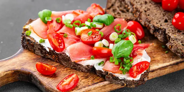 Jambon, domates, yeşillik taze lezzetli gurme yemek arkaplanı masa kırsal yiyeceklerin üst görünümü fotokopi alanı.