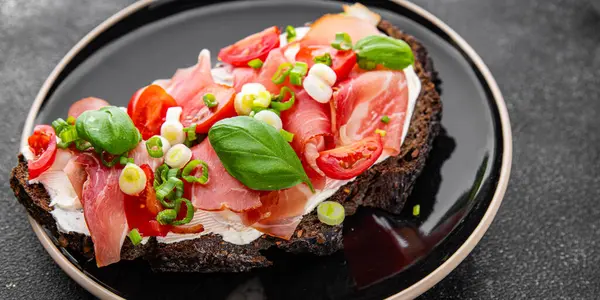 Jambon, domates, yeşillik taze lezzetli gurme yemek arkaplanı masa kırsal yiyeceklerin üst görünümü fotokopi alanı.