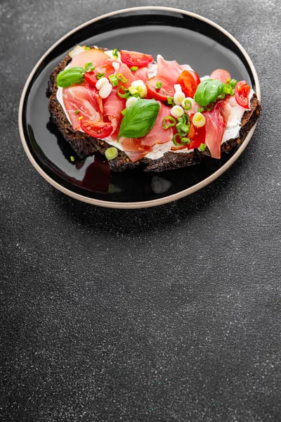 Jambon, domates, yeşillik taze lezzetli gurme yemek arkaplanı masa kırsal yiyeceklerin üst görünümü fotokopi alanı.