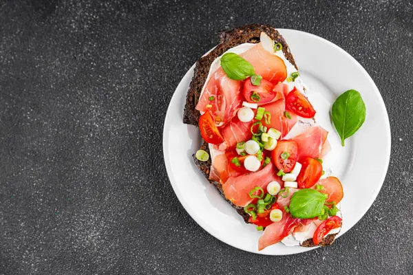 Jambon, domates, yeşillik taze lezzetli gurme yemek arkaplanı masa kırsal yiyeceklerin üst görünümü fotokopi alanı.