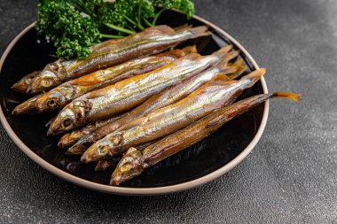 Tütsülenmiş balık capelin tabağı taze gurme yemek arka planda masa rustik gıda üst görünüm fotokopi alanı pesseeter diyet