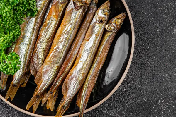 Tütsülenmiş balık capelin tabağı taze gurme yemek arka planda masa rustik gıda üst görünüm fotokopi alanı pesseeter diyet