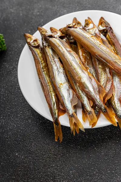 Tütsülenmiş balık capelin tabağı taze gurme yemek arka planda masa rustik gıda üst görünüm fotokopi alanı pesseeter diyet