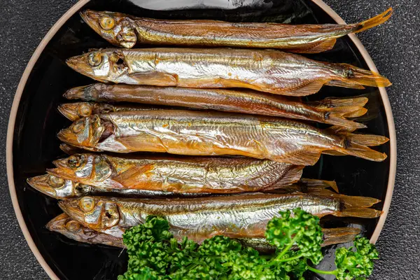 Tütsülenmiş balık capelin tabağı taze gurme yemek arka planda masa rustik gıda üst görünüm fotokopi alanı pesseeter diyet