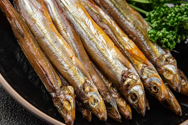 Tütsülenmiş balık capelin tabağı taze gurme yemek arka planda masa rustik gıda üst görünüm fotokopi alanı pesseeter diyet