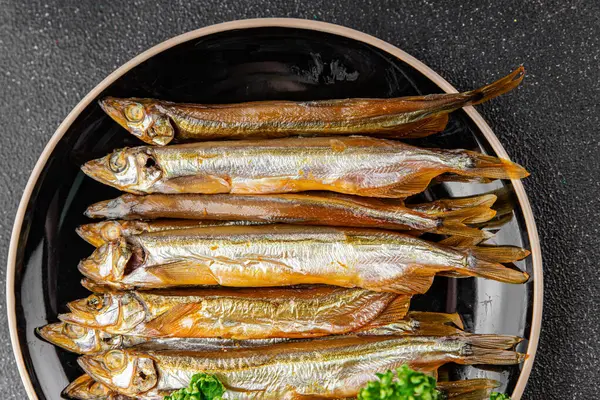 Tütsülenmiş balık capelin tabağı taze gurme yemek arka planda masa rustik gıda üst görünüm fotokopi alanı pesseeter diyet