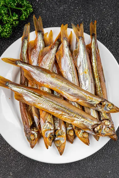 Tütsülenmiş balık capelin tabağı taze gurme yemek arka planda masa rustik gıda üst görünüm fotokopi alanı pesseeter diyet