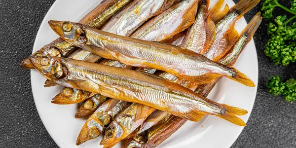 Tütsülenmiş balık capelin tabağı taze gurme yemek arka planda masa rustik gıda üst görünüm fotokopi alanı pesseeter diyet