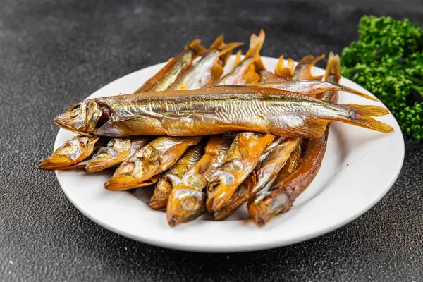 Tütsülenmiş balık capelin tabağı taze gurme yemek arka planda masa rustik gıda üst görünüm fotokopi alanı pesseeter diyet