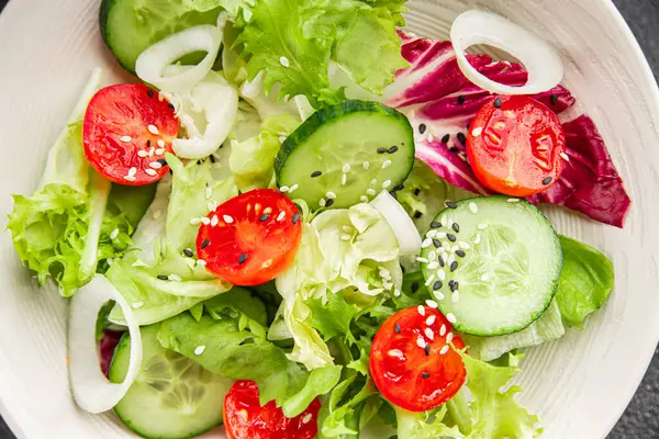 Sebzeli salata, domates, salatalık, marul, yeşil yaprak, marul, soğan mezesi sebze, taze gurme yemek arka plan kırsal gıda üst görünüm fotokopi alanı 