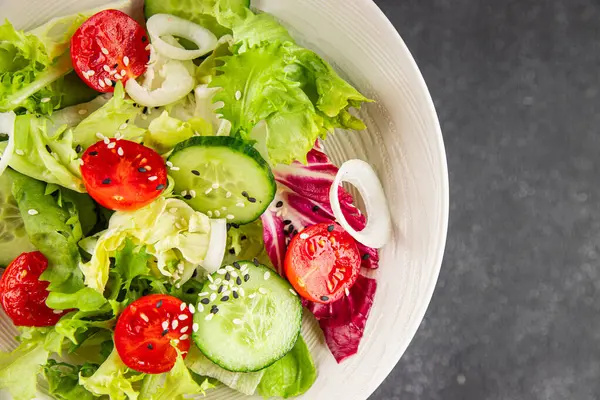 Sebzeli salata, domates, salatalık, marul, yeşil yaprak, marul, soğan mezesi sebze, taze gurme yemek arka plan kırsal gıda üst görünüm fotokopi alanı 