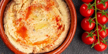 Humus nohut sosu baharatlar iştah açıcı sebzeler taze gurme vejetaryen ve vejetaryen yemek arka planı masa kırsal gıda üst görünümü 