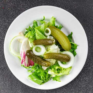 Salatalık turşusu salatalık turşusu karışık yeşil yaprak salatası iştah açıcı sebze yemeği taze organik lezzetli gurme yemek arka planı masanın üzerinde.