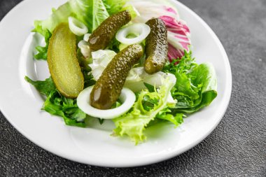 Salatalık turşusu salatalık turşusu karışık yeşil yaprak salatası iştah açıcı sebze yemeği taze organik lezzetli gurme yemek arka planı masanın üzerinde.