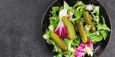 Salatalık turşusu salatalık turşusu karışık yeşil yaprak salatası iştah açıcı sebze yemeği taze organik lezzetli gurme yemek arka planı masanın üzerinde.