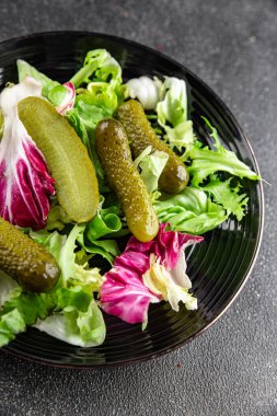 Salatalık turşusu salatalık turşusu karışık yeşil yaprak salatası iştah açıcı sebze yemeği taze organik lezzetli gurme yemek arka planı masanın üzerinde.