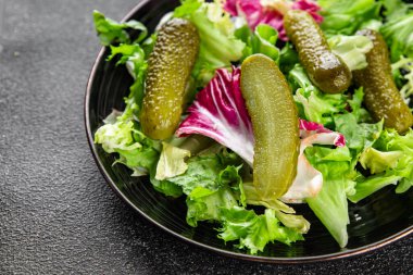 Salatalık turşusu salatalık turşusu karışık yeşil yaprak salatası iştah açıcı sebze yemeği taze organik lezzetli gurme yemek arka planı masanın üzerinde.