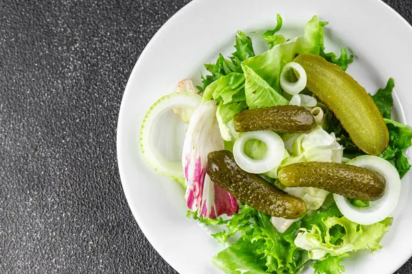Salatalık turşusu salatalık turşusu karışık yeşil yaprak salatası iştah açıcı sebze yemeği taze organik lezzetli gurme yemek arka planı masanın üzerinde.