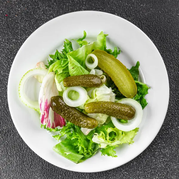 Salatalık turşusu salatalık turşusu karışık yeşil yaprak salatası iştah açıcı sebze yemeği taze organik lezzetli gurme yemek arka planı masanın üzerinde.