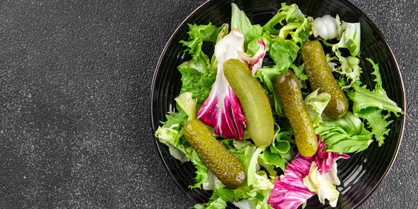 Salatalık turşusu salatalık turşusu karışık yeşil yaprak salatası iştah açıcı sebze yemeği taze organik lezzetli gurme yemek arka planı masanın üzerinde.