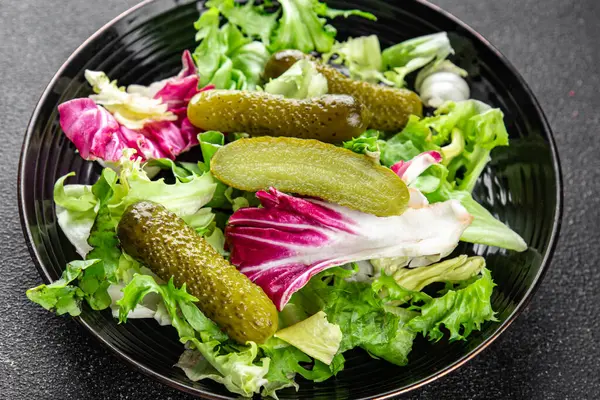 Salatalık turşusu salatalık turşusu karışık yeşil yaprak salatası iştah açıcı sebze yemeği taze organik lezzetli gurme yemek arka planı masanın üzerinde.