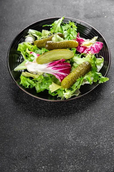 Salatalık turşusu salatalık turşusu karışık yeşil yaprak salatası iştah açıcı sebze yemeği taze organik lezzetli gurme yemek arka planı masanın üzerinde.