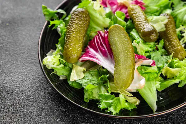 Salatalık turşusu salatalık turşusu karışık yeşil yaprak salatası iştah açıcı sebze yemeği taze organik lezzetli gurme yemek arka planı masanın üzerinde.