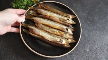 Balık tütsülenmiş kapelinli sprat yemeği taze lezzetli gurme yemek arka planda masa rustik gıda üst görünüm fotokopi alanı pesseeter diyet