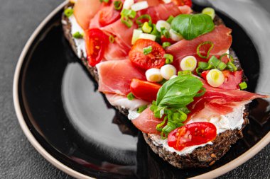 Jambon, domates, yeşillik taze lezzetli gurme yemek arkaplanı masa kırsal yiyeceklerin üst görünümü fotokopi alanı.