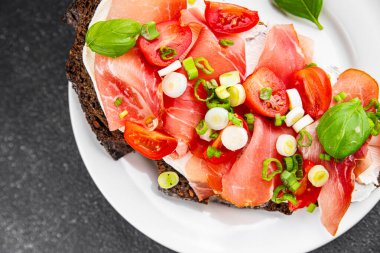 Jambon, domates, yeşillik taze lezzetli gurme yemek arkaplanı masa kırsal yiyeceklerin üst görünümü fotokopi alanı.