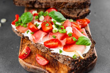 Jambon, domates, yeşillik taze lezzetli gurme yemek arkaplanı masa kırsal yiyeceklerin üst görünümü fotokopi alanı.