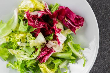 Salata karışık yeşil yapraklı buzdağı, batavya, marul, turşu, romano, arkadaş iştah açıcı sebzeler organik taze lezzetli gurme yemek arka planı masa fotokopisi alanı üzerinde 