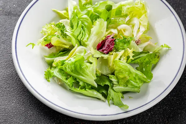 Salata karışık yeşil yapraklı buzdağı, batavya, marul, turşu, romano, arkadaş iştah açıcı sebzeler organik taze lezzetli gurme yemek arka planı masa fotokopisi alanı üzerinde 