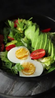 Avokado salatası, haşlanmış yumurta, domates, yeşil yaprak, marul, sebze yemeği taze lezzetli gurme yemek arka planda masanın üstünde rustik yiyecekler fotokopi alanı keto ve paleo diyeti vejetaryen yemekleri