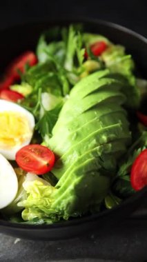 Avokado salatası, haşlanmış yumurta, domates, yeşil yaprak, marul, sebze yemeği taze lezzetli gurme yemek arka planda masanın üstünde rustik yiyecekler fotokopi alanı keto ve paleo diyeti vejetaryen yemekleri