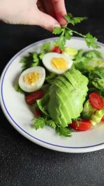 Avokado salatası, haşlanmış yumurta, domates, yeşil yaprak, marul, sebze yemeği taze lezzetli gurme yemek arka planda masanın üstünde rustik yiyecekler fotokopi alanı keto ve paleo diyeti vejetaryen yemekleri