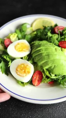 Avokado salatası, haşlanmış yumurta, domates, yeşil yaprak, marul, sebze yemeği taze lezzetli gurme yemek arka planda masanın üstünde rustik yiyecekler fotokopi alanı keto ve paleo diyeti vejetaryen yemekleri