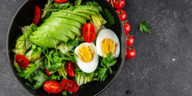 Avokado salatası, haşlanmış yumurta, domates, yeşil yaprak, marul, sebze yemeği taze lezzetli gurme yemek arka planda masanın üstünde rustik yiyecekler fotokopi alanı keto ve paleo diyeti vejetaryen yemekleri