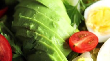 Salata avokado, haşlanmış yumurta, domates, yeşil yaprak marul, sebze tabağı taze lezzetli gurme yemek arkaplanı masa kırsal yiyeceklerin üst görünümü fotokopi alanı.