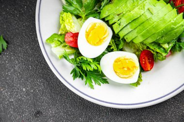 Salata avokado, haşlanmış yumurta, domates, yeşil yaprak marul, sebze tabağı taze gurme yemek arkaplan masanın üzerinde rustik yemek üst görünüm fotokopi uzay vejetaryen gıda